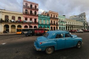 Kleurrijke oldtimers geparkeerd voor koloniale gebouwen in Havana, Cuba