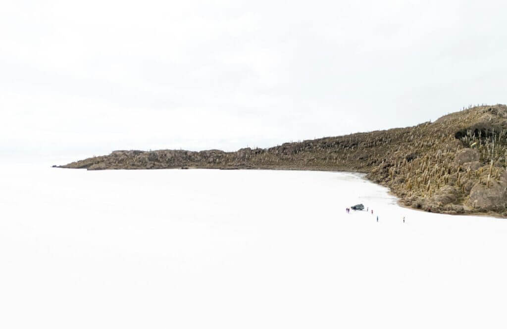 Jeep op de uitgestrekte zoutvlakte van Salar de Uyuni, Bolivia