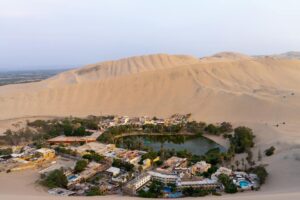 De oase van Huacachina omringd door torenhoge zandduinen in de woestijn van Peru
